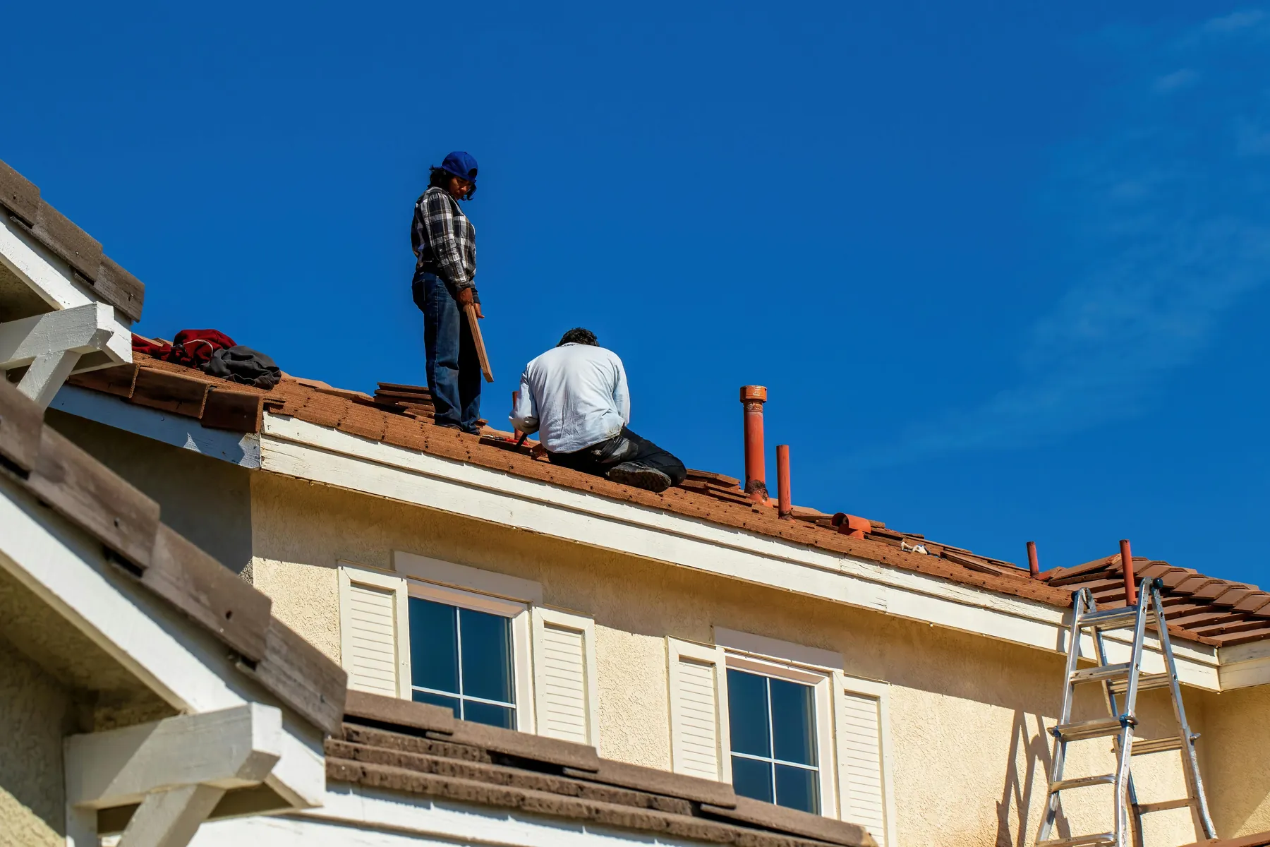 Dachdecker bringt neue Dachschindeln an